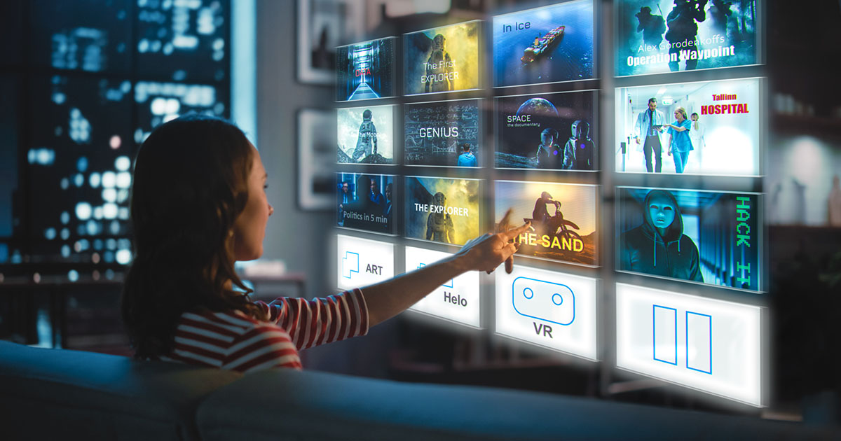 A woman streaming video sits on a couch and selects a tile from a floating video menu